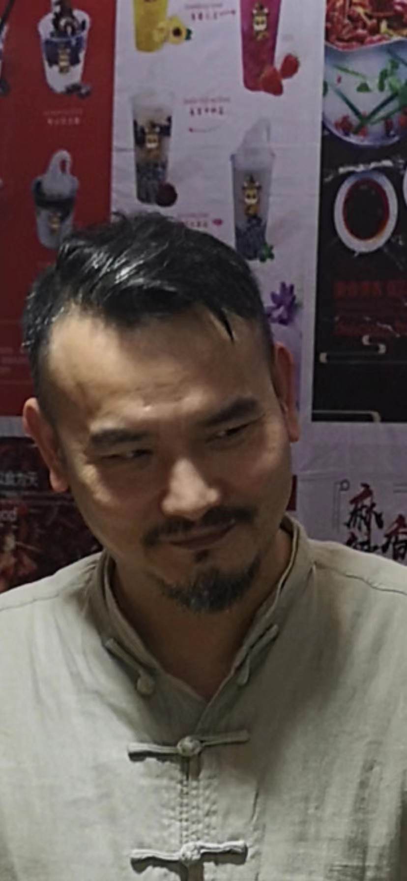 餐饮店内穿着中式立领盘扣上衣的中年男性